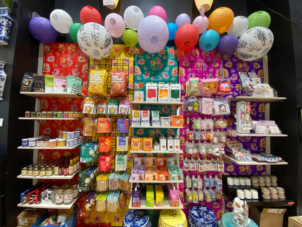 Display of products in Pearl River Mart Soho store with lanterns and colorful wallpaper