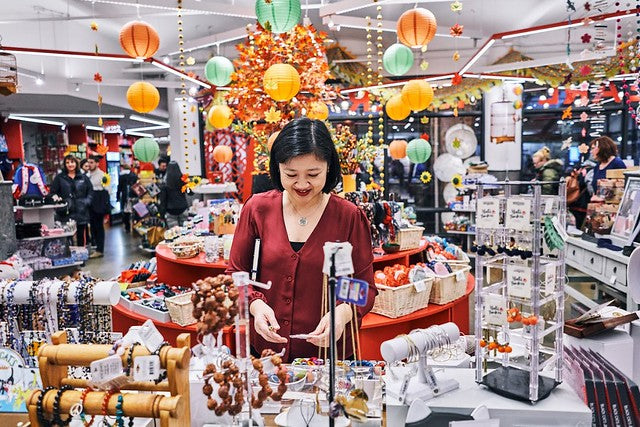 Joanne Kwong arranging jewelry table at Pearl River Chelsea Market location