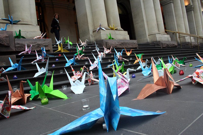Many origami cranes on the steps of a building