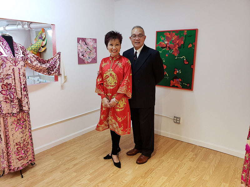 Chinese opera performer Mee Mee Chin and artist Arlan Huang in front of Arlan's paintings and Mee Mee's opera costume in the Pearl River Mart gallery in Tribeca 