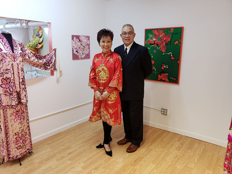 Chinese opera performer Mee Mee Chin and artist Arlan Huang in front of Arlan's paintings and Mee Mee's opera costume in the Pearl River Mart gallery in Tribeca