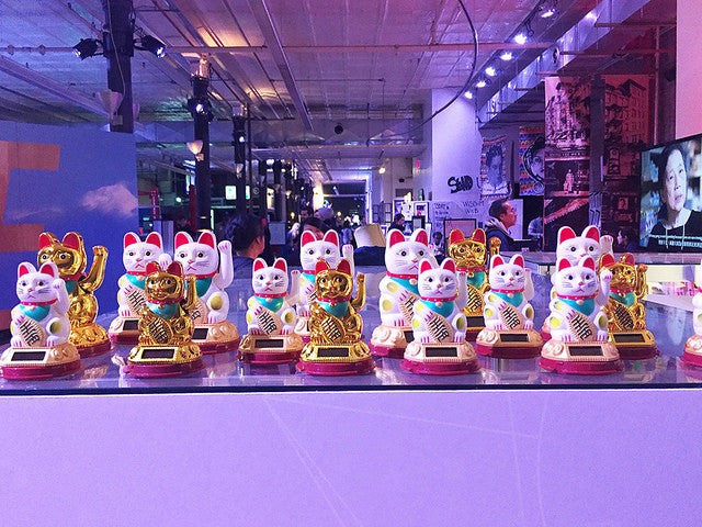 Display of white and gold lucky cats as part of an art exhibition