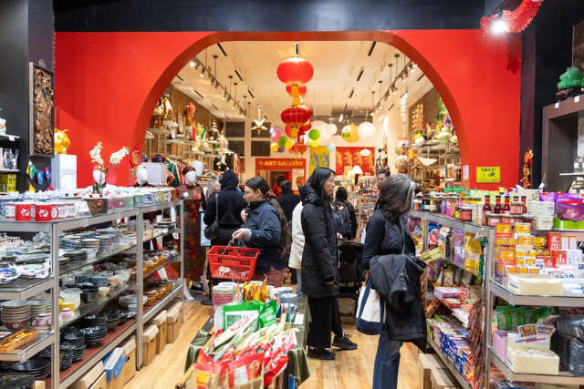 Store interior with shelves stocked with products and people shopping.