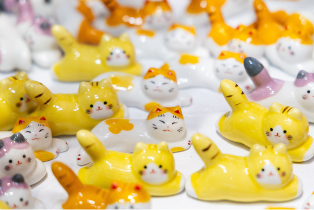 Array of ceramic cat chopstick rests in yellow and white