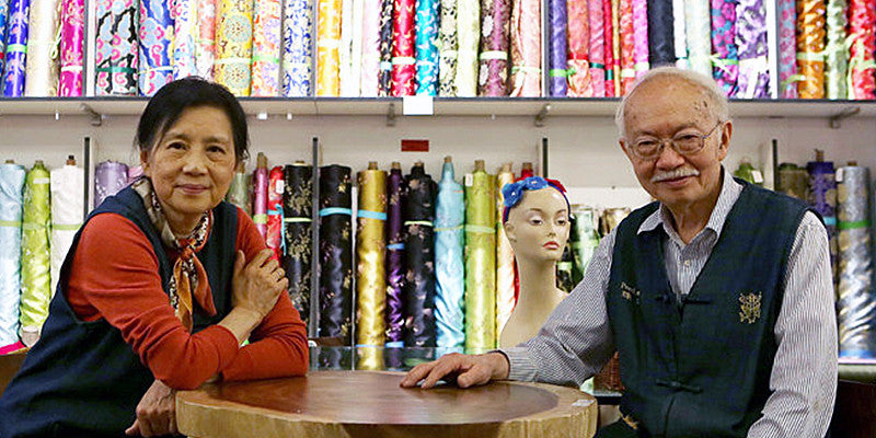 Mr. and Mrs. Chen in front of fabric dispaly at Pearl River Mart