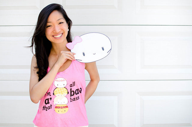 Cynthia Koo in pink tank top holding dumpling cartoon cutout