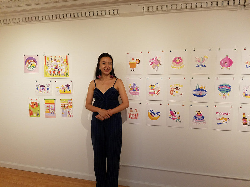 Artist Dingding Hu in front of her illustrations in the Pearl River Mart gallery in Tribeca