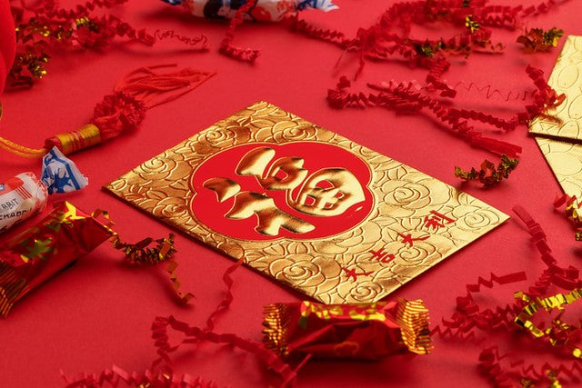 Gold fu envelope surrounded by red streamers and various candy