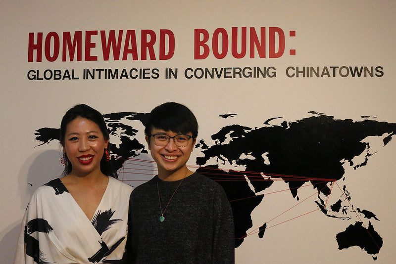 Curators Diane Wong and Huiying B. Chan in front of a global map in the Pearl River Mart gallery in Tribeca