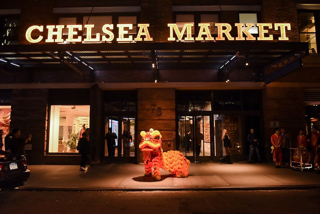 Lion dancer in front of Chelsea Market at night