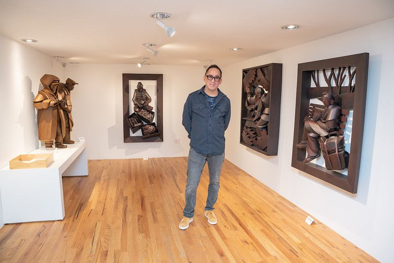 Artist Warren King surrounded by his cardboard sculptures in the Pearl River Mart gallery