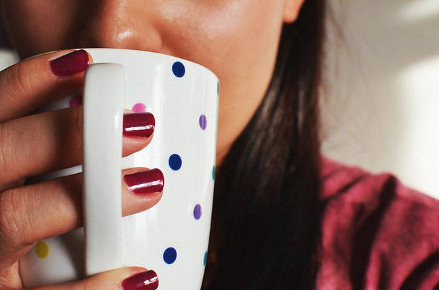 Woman drinking mug of hot tea
