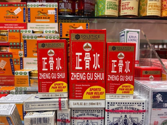 Three different-sized red boxes of Zheng Gu Shui medicine near other Chinese traditional medicines