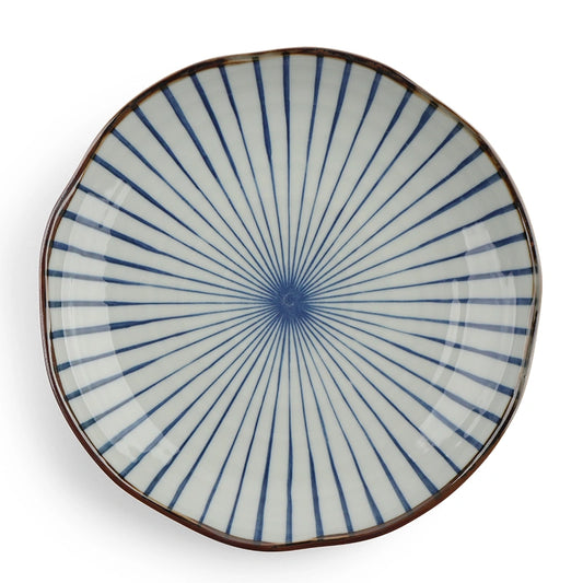 A round ceramic plate with a white base and a pattern of blue radial lines emanating from the center, surrounded by a brown rim. The tone is elegant and classic.