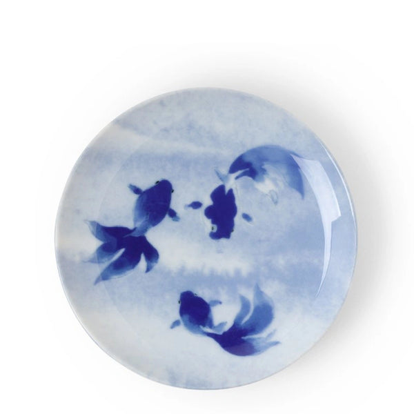 Round ceramic plate with blue fish design on a white background