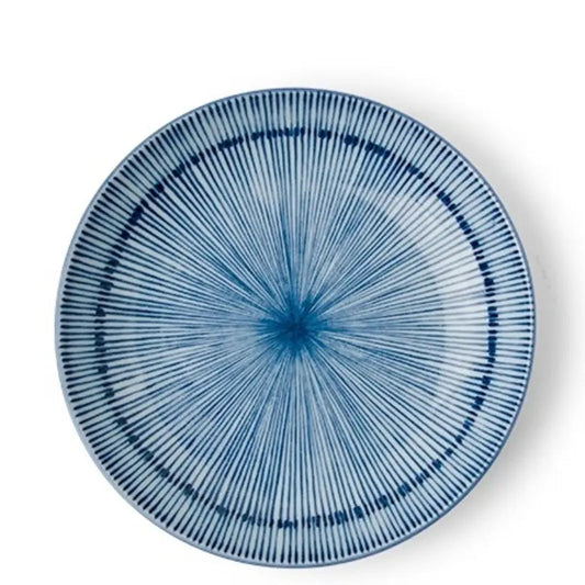 A round ceramic plate with a blue and white radial starburst pattern, photographed from directly above on a white background.