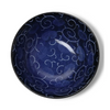Blue ceramic bowl with intricate patterns on a white background