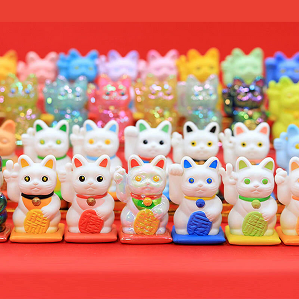 Colorful cat-shaped figurines on a red background