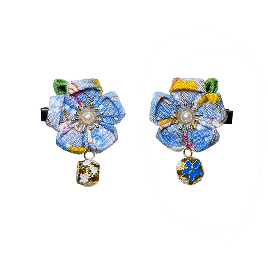 Pair of decorative hair clips with floral design and pearl-like beads on a white background