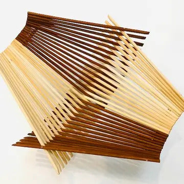 Folding basket made with 30 pairs of natural and tea stained colored chopsticks in a quad pattern