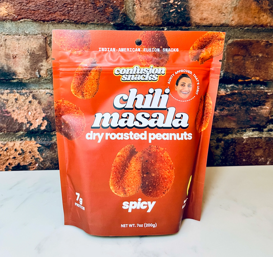 Packaging of Confusion Snacks chili masala dry roasted peanuts against a brick wall background