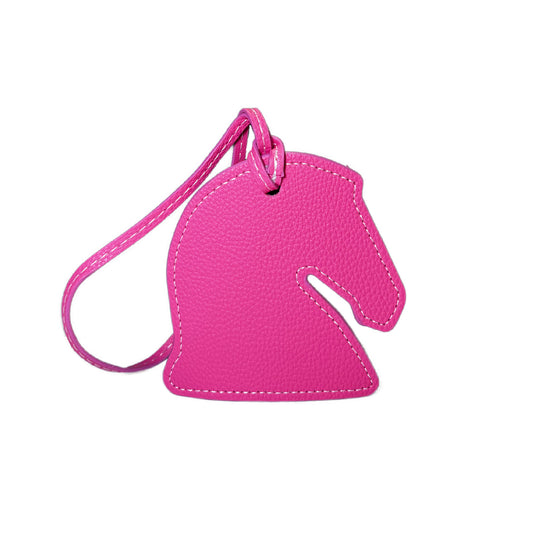 Pink horse-shaped luggage tag on a white background