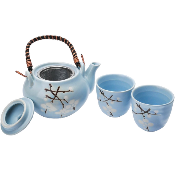 Blue ceramic teapot and two cups with branch design on a white background
