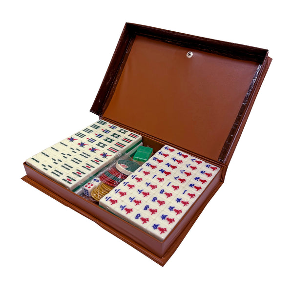 Mahjong set with tiles, dice, and chips in a brown case on a white background