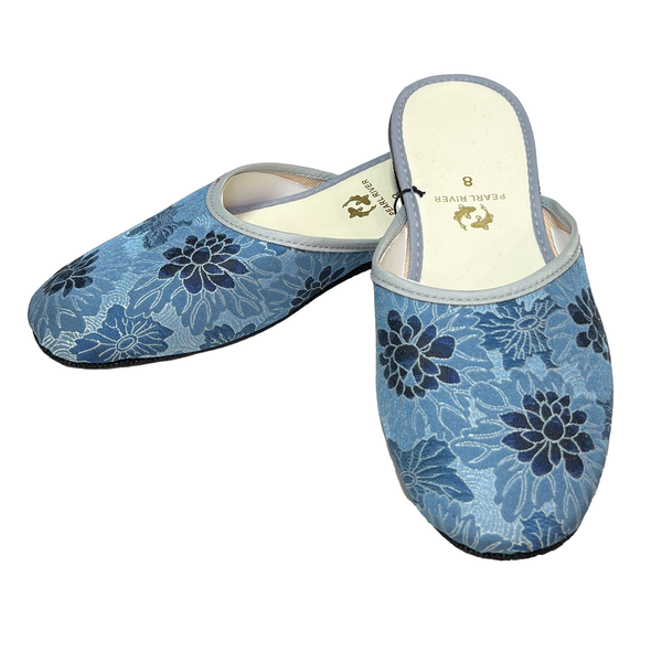 Pair of blue floral-patterned slippers on a white background