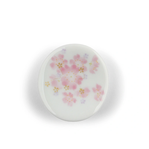 Round ceramic chopstick rest with floral pattern on a white background