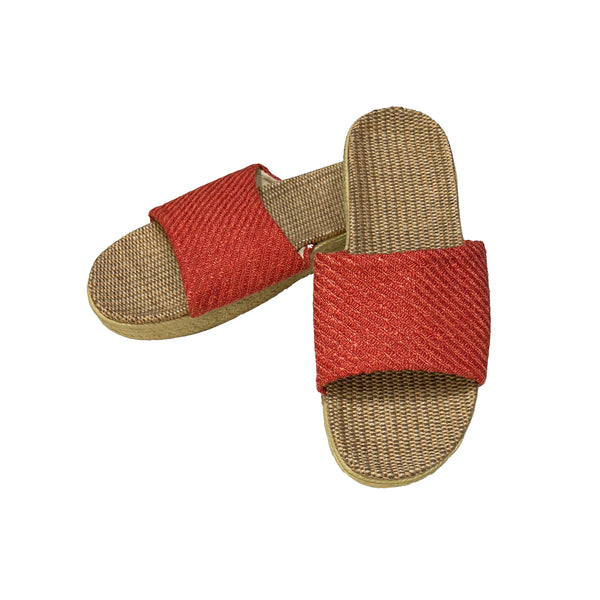 Pair of sandals with red woven straps on a white background