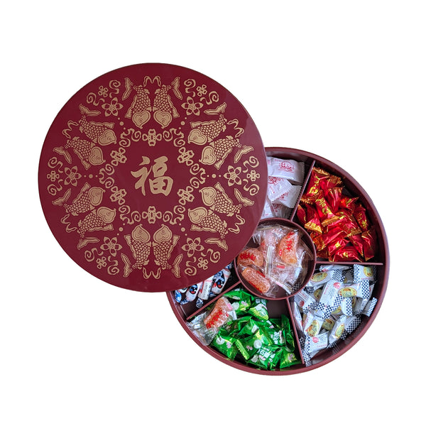 Decorative red box with gold patterns containing various types of candy.