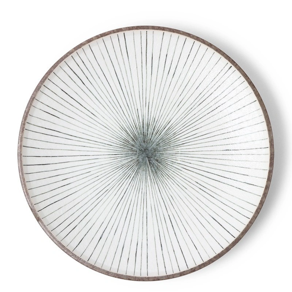 Round decorative plate with radiating lines on a white background