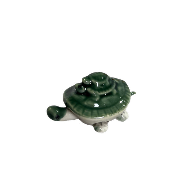 Green ceramic turtle figurine on a white background