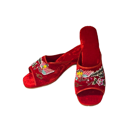 A pair of red velvet open-toe mule sandals decorated with colorful floral and bird embroidery and sequins, shown on a plain white background.