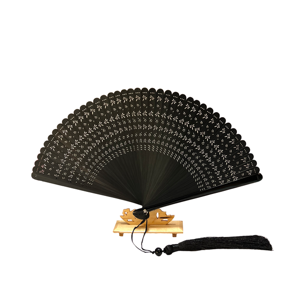 Black fan with lace design and tassel on wodden stand