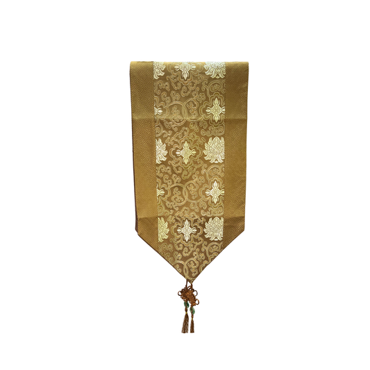 Decorative table runner with gold and white pattern on a white background