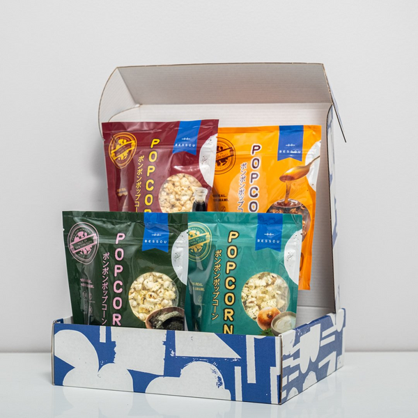 Box of popcorn packages with various designs on a white background