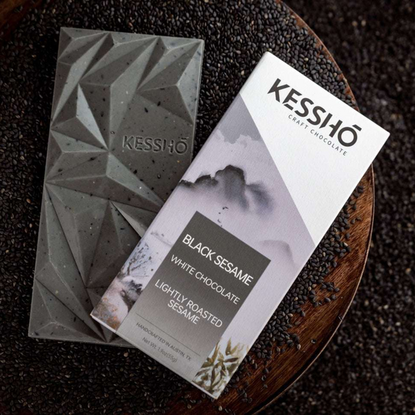 Kessho craft chocolate bars on a dark surface with sesame seeds