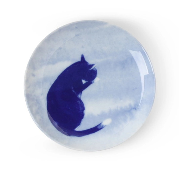 Round blue and white ceramic plate with a cat design on a white background