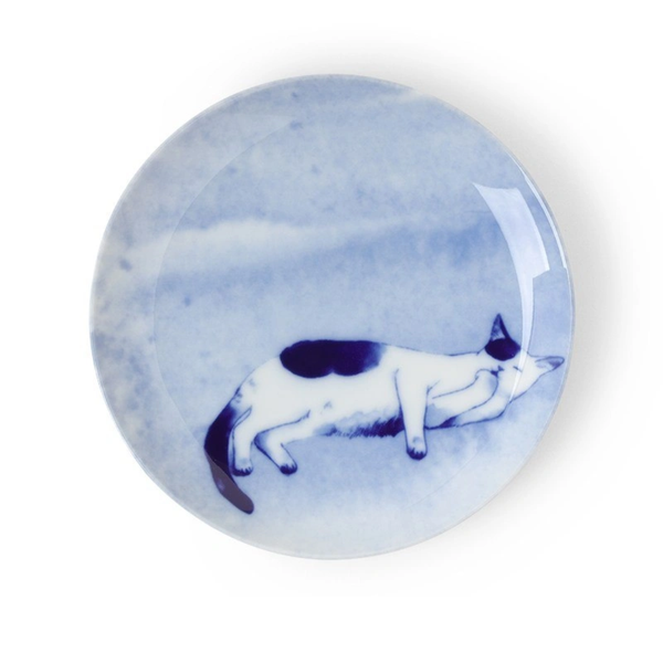 Round blue and white ceramic plate with a cat design on a white background