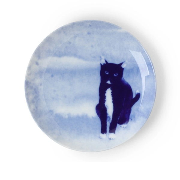 Round ceramic plate with a black cat design on a blue and white speckled background