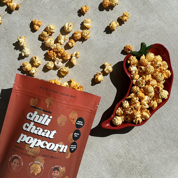 Red bag of chili chaat popcorn and hot pepper shaped dish with popcorn
