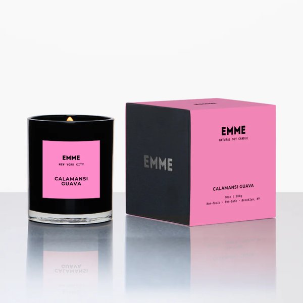 Black candle with pink label and matching box on a white background