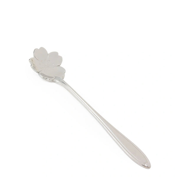 Silver spoon with a decorative head on a white background