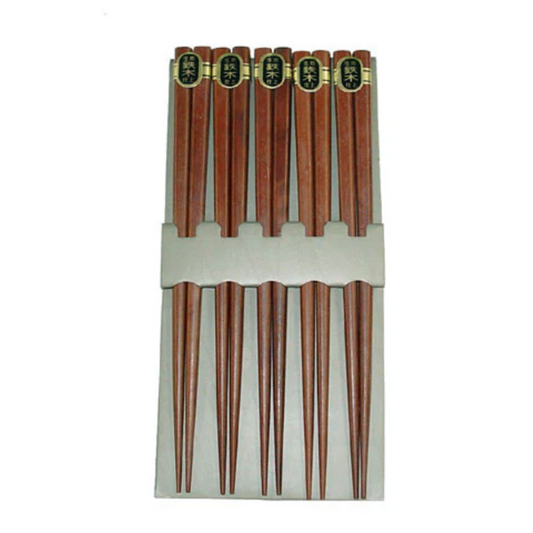 Set of wooden chopsticks in a white holder on a white background