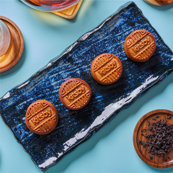 Four Kitsby mooncakes on a dark blue plate