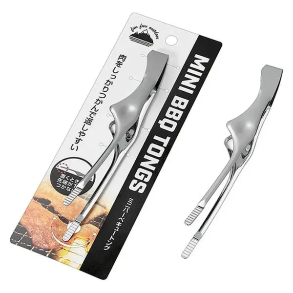 Two silver metal mini BBQ tongs shown beside their retail backing card on a plain white background. The card has black and white packaging with Japanese text and a small food graphic.