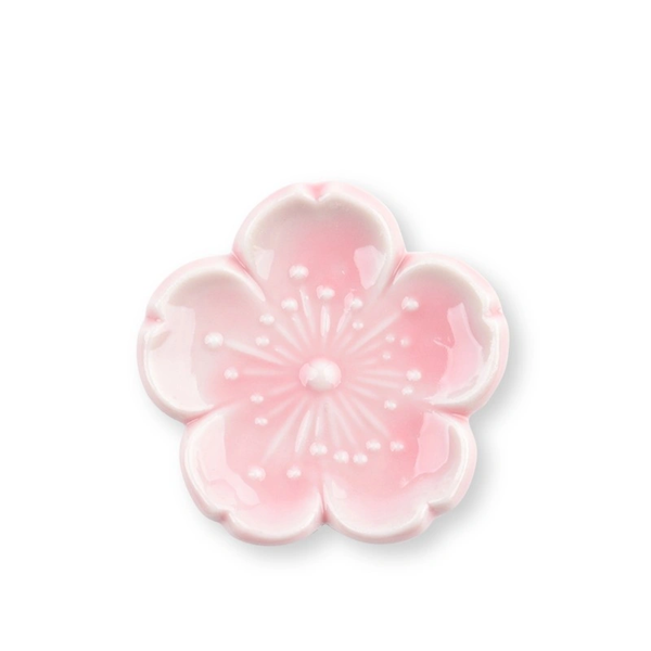 Pink flower-shaped chopstick rest on a white background
