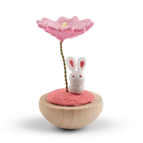 Small wooden toy with a pink flower and rabbit on a white background